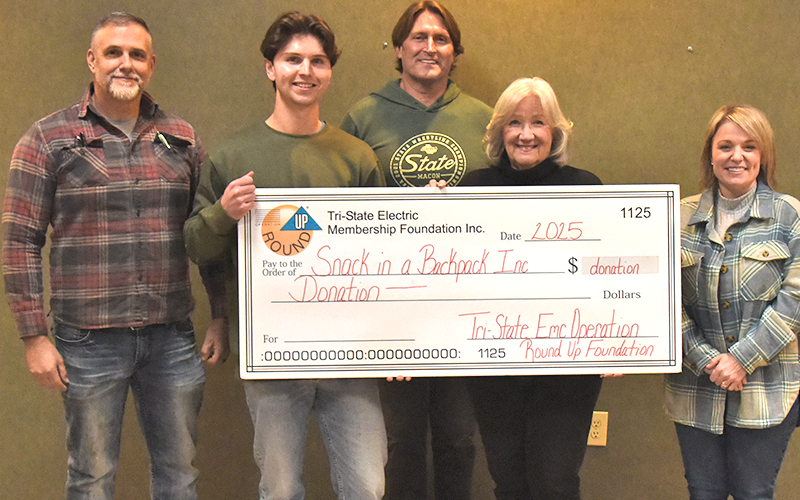 Tri-State Roundup board members Chris Foster, Alan Collis and Amber Mitchell presented Debby Beck and Cooper Boyle with a donation check for Snack in a Backpack, one of the grants that put the member supported program over $1 million in grants to area organizations.