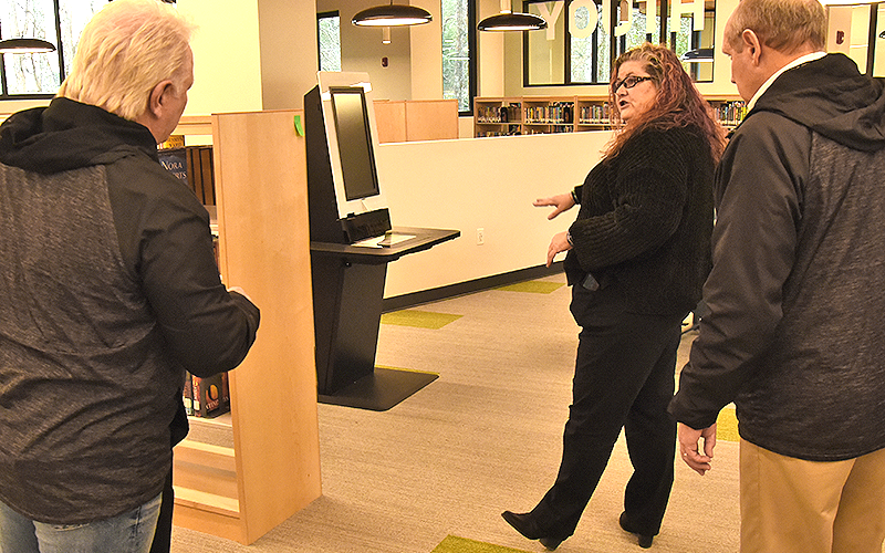 Fannin County Public Library employee McKenna Shewmake explains the self checkout station to Fannin County commissioners Johnny Scearce, left, and Glenn Patterson. The library is set to officially open to the public this Saturday, March 7.