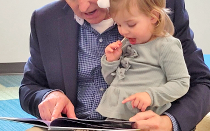 News Observer photo/Glenn Harbison: State Representative Johnny Chastain reads to his granddaughter, Hazel, during the grand opening of the Fannin County Public Library Saturday in Blue Ridge.