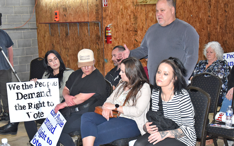 McCaysville restaurant owner Mike Galinski, standing, was among those who asked the McCaysville City Council to allow a liquor by the drink question be put on a ballot. Among several carrying signs that said, “We the People Demand the Right to Vote” was Sheila Toorgeman, far left, manager of the Burra Burra on the River and Twisted Tomato restaurants in McCaysville.