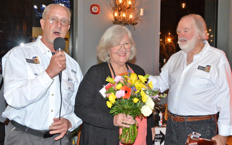 Snack in a Backpack Executive Director Debby Beck was recognized for her service during the organization’s annual Champions for Children Fundraiser March 2. Shown recognizing Beck are board members Greg Spencer, left, and Carl Pruett.