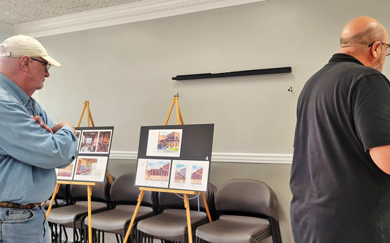 Dale Greene, left, and Troy Shirbroun check out site plans during a “Community Input Session” hosted by the developer, Rich Chism of Heron Hotels.