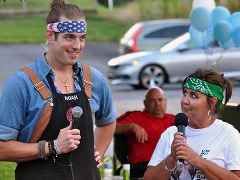 Fannin County’s Noah Sims was a contestant on Fox network’s MasterChef Season 10 television show and made it to the top four home chefs. Blue Ridge Mayor Donna Whitener helped organize a Noah Night watch party in the downtown park September 11. Shown are Sims and Whitener speaking with the folks who came to watch the show.