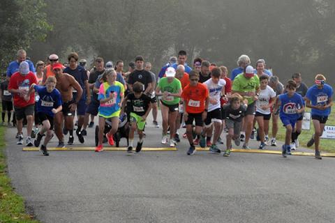 Runners pass the starting line at the Boys & Girls Club of North Georgia Labor Day 5K River Run at Horseshoe Bend Park Saturday, August 31.