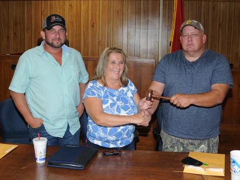 Debbie Davis, who represents District 1, was elected chairwoman of the Polk County Board of Commissioners Thursday, September 26. Here, she receives the gavel from outgoing Chairman Greg Brooks, right. Incoming Vice Chairman Jeremy Kimsey, who represents District 3, is at left.