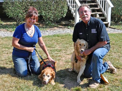 Diane Aradi smiles while petting the newest addition of their family Goldie. Also shown is husband Lester with rescue Hope. Hope was born with Cerebellar Hypoplasia. The condition affects the dog’s fine motor skills, balance and coordination.