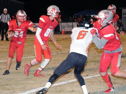 Cougar Chase Mickens (24) runs the ball while Cody Montgomery (85) looks for a defender to block and Eli Patterson (22) holds off a defender.