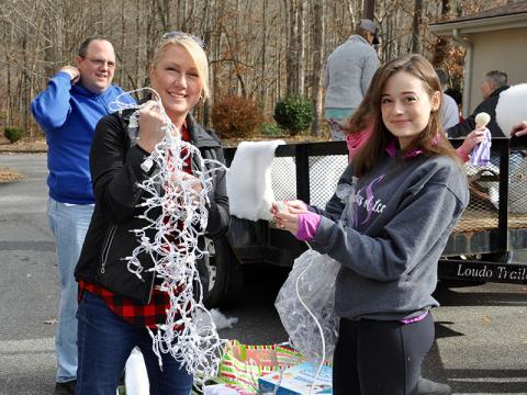 Amy, left, and Hannah Price smile while testing the icicles lights for the Fannin County Special Olympics Light Up Blue Ridge parade float Friday, November 29.