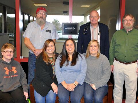 Family and friends gathered Monday, December 16, at the Riverstone Medical Campus in Blue Ridge to honor those who died in a plane crash near Blairsville Municipal Airport December 19, 2018. Gathering on and around a bench dedicated to the deceased are, from left, front row, Survivor Brittany Whitener, Michelle Seay’s daughters Anna Deyton, Katie Bergen and Brittany Combs; back Renea Greiner’s husband Richard, Dr. Raymond Tidman and Dr. Stan Trigg.