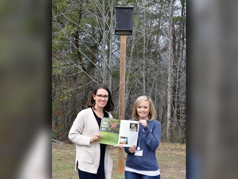 Parent Jocelyn Miller, left, and West Fannin Elementary teacher Katy Roberson show off their article in the January 2020 issue of “Science and Children.” Behind the two is a bat box that was designed and constructed by Roberson’s first grade students.
