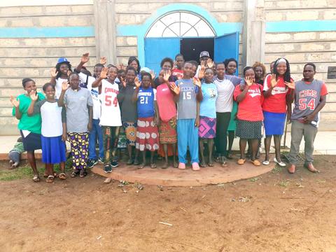 Tharaka-Nithi County, Kenya children wave to the camera while wearing their new Copper Basin and Fannin County sports shirts, donated by Tim and Debbie Smith of North Georgia Sports Zone.