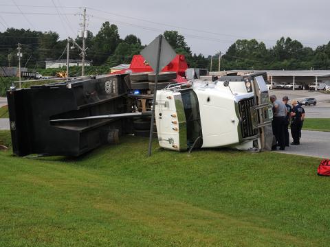 A Lance Trucking company dump truck lies on its side just off Windy Ridge Circle after the dump bed struck a power line Friday morning. Power was knocked out to over 800 customers. The power pole snapped when the truck pulled down a line can be seen in the background.