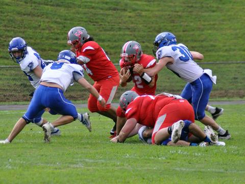 Sebastian Balilies (12) fights through defenders as Krus Sotos (54) and Chance Rollins (77) block  during the Cougars 14-12 win over Georgia Force Friday, August 28.