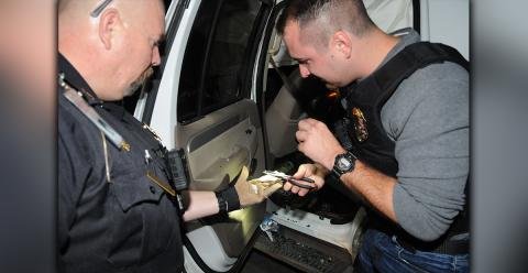 McCaysville Police Chief Mike Earley, right, used needle-nosed pliers to pick shards of crystal methamphetamine from a suspect’s wrecked vehicle Saturday night in McCaysville. Detective Cory Collogan, along with other McCaysville officers, helped collect the evidence, which includes 16  and 1/2 grams of heroin. 