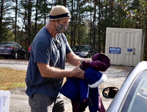 Fannin County Family Connection volunteer John Rutland hands off some coats raised through The New Observer’s annual Coats for Kids coat drive Thursday, November 5, at Family Connection’s facility.