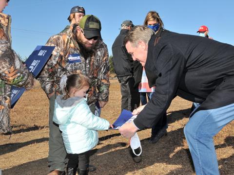 Georgia's senior U.S. Senator David Perdue brought his Win Georgia, Save America campaign to Fannin County last Tuesday, December 8. Perdue, who is seeking re-election in the January 5 runoff, quoted Ronald Reagan when he told supporters, "Freedom is just one generation away from extinction." Here, he greets a member of the next generation, Khloe Robinson, as her father, Jeremiah, looks on.