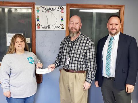 Fannin County Department of Family and Children Services (DFCS) Board of Directors Chairman James Jones presents a $4,500 check to Renee Bell, president of the Foster Parent Association, Wednesday, December 9. Beside Jones is Fannin DFCS Director Mark Knowles. The Association raises funds for foster children’s Christmas gifts, yearbooks, class rings, clothes, crutches and other things needed for the children.