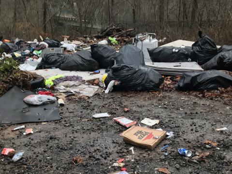Garbage in this dump site in the Shuler Creek area of Polk County revealed the names of four Georgia residents. Those residents have been charged by U.S. Forest Service law enforcement officers and face federal penalties if convicted.