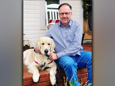 Charlie the Therapy Dog is shown with one of his favorite people, Reverend Asa Dockery.