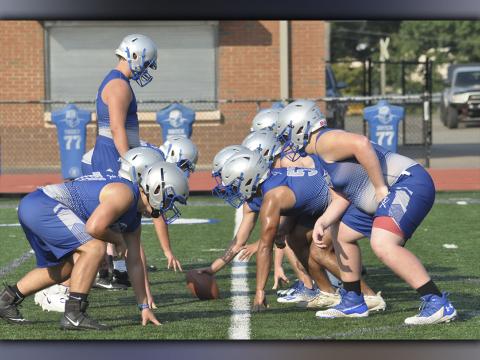 Offensive and defensive linemen line up and go through plays during the Rebels football practice Thursday, July 29.