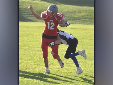 Copper Basin Middle School quarterback Dawson Pittman shakes off a defender during the Cougars game against Bradley County Thursday, September 2.