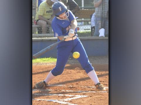 Riley Davis unloads on a ball in recent action for the Lady Rebels softball team.