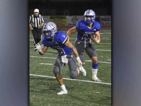Austin Garland (18) leads the way for Seth Reece (23) in recent action for the Fannin County Rebel football team. Fannin topped Coosa 37-7 Friday, October 29, to remain undefeated in region play.