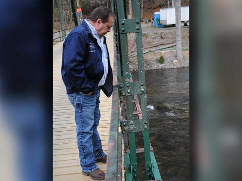 Fannin County Public Works Director Zack Ratcliff inspects repairs to a gusset plate on Shallowford Bridge. Those repairs included painting the work area, part of which lies below the main steel beam and is not visible.