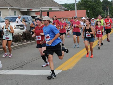 Runners turn the corner on to Blue Ridge Drive as they begin the Walk the Line 5K in McCaysville Saturday evening, July 2. The event is part of the Riverwalk Run Series that features a course covering two states and crossing two bridges. The run kicked off Saturday evening festivities that included a fireworks show from Tater Hill in McCaysville and live music at Tooney’s Music Venue.