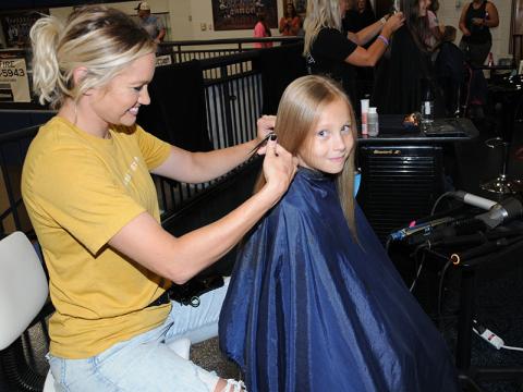 Celeste Lance styles Oliva Roesch’s hair during the Summer Bash at Fannin County High School Saturday, July 9. The event started with a conversation between Lance and the school system’s licensed clinical social worker, Sheena Rymer. Lance was one of several hair stylists who donated their time Saturday.