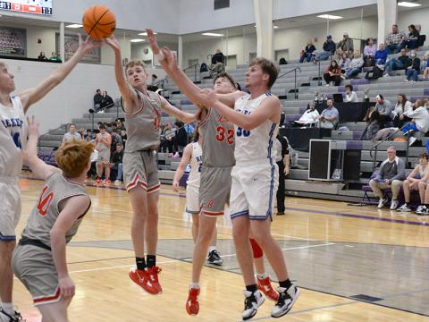 The Rebels and the Cougars all fight for a rebound in last Tuesday’s ETC Tipoff Tournament matchup. For the Cougars, from left, Kelle Shroth, Talon Smith and Reece Parris go for the ball, and for the Rebels, Lucus Hanson, left, and Gavin Mowery, right, fight to get a hand on it. 