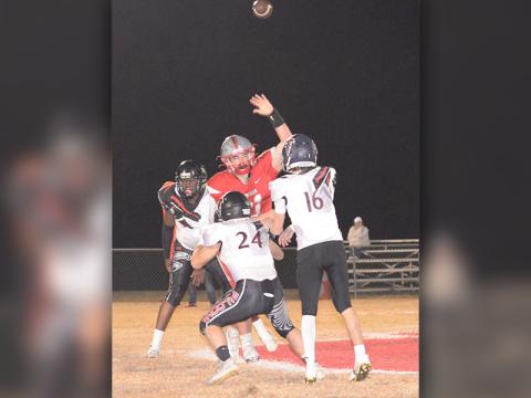 Addison Hook (61) jumps and throws a hand up to try to deflect the pass made by the opposing quarterback.