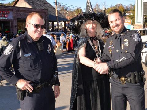 McCaysville Police Chief Michael Earley, right, and Officer Pete Kusek  were not sure about the  intention of this  visitor at McCaysville’s Safe Zone, so they detained her for questions. She turned out to be city Councilman Susan Kiker who proclaimed to ba a “good witch” watching over the festivities.