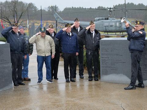 Rain fell as Richard Crosley, right, played taps at the conclusion of the Pearl Harbor Memorial Ceremony. Shown honoring those who gave their lives that day are, from left, Bill Stodghill, Kevin O’Quinn, Larry Dyer, Gerald “Chief Mac” McMillan, Ronnie Rabun, Ron Wallace and Steve Strickland.