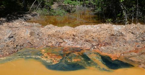 The orange water is the ground water/mine water at the head of the Copperhill Industries area. Buddy Haynes explains that is the color before the water is treated with biosolids through a series of ponds. At this stage it is about a pH2. Once treated, it turns green, as is seen above, and the pH level reaches 6 to 8, which is capable of sustaining aquatic life.