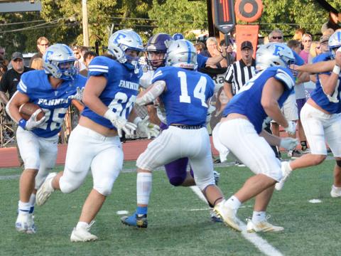 The Fannin County High School Rebels work together to defeat the Gilmer County Bobcats Friday, August 25, 38 to 14. Rebel Carson Callihan (#25) runs the ball while his teammates Jacob Dye (#60), Cooper Born (#14), Case Holloway (#62), and Noah Burnett (#72) work hard to create a hole for him to run through.  (Photo by Glenn Harbison)