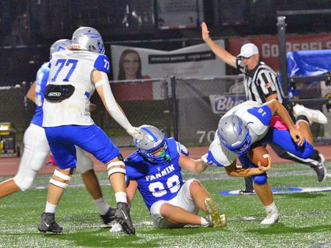 Case Holloway holds on for a quarterback sack against the Gordon Central Warriors Friday night in Blue Ridge. The Rebels scored a 42-0 advantage for their first region win of the season.