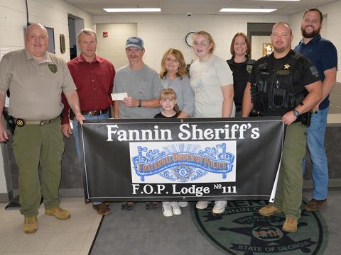 Skylar and Riley Gazaway received proceeds from the Corporal Richard Gazaway Memorial Golf Tournament last week. Shown during the presentation of the check at the Fannin County Sheriff’s Office are, from left, Investigations Sergeant J.K. Davenport, Sheriff Dane Kirby, Wayne Stover accepting the donation for the children, Riley Gazaway, Glenda Stover, Skylar Gazaway, Investigator Erin Sehl, Sergeant Jacob Pless and Investigator Dustin Carder.