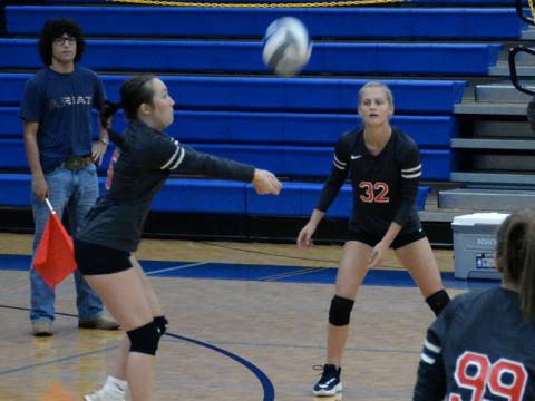 Maddie Cribbs sets up a return for the Lady Cougars as Riley Hall (32) waits fo the shot.