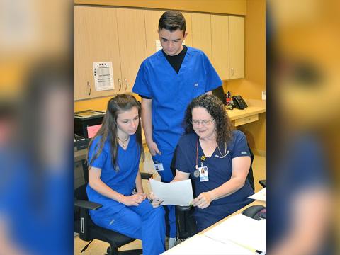  Students Blair Deal and Trent Davis look over a patient’s chart with LPN Candy Burgess at Georgia Mountains Health. The two students are juniors at Fannin County High School and are a part of the General Medicine class’ clinical rotation program. 