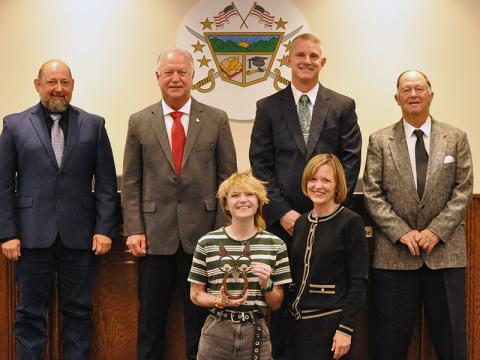 Lauralee Callegari, front left, staff writer for The News Observer, was recognized by School Superintendent Shannon Dillard-Miller, front right, for her articles covering recent school system events and news. Shown during the presentation of an handmade owl, the school system’s special honor recognizing wisdom and knowledge, are school board members, back from left, Mike Cole, Terry Bramlett, Bobby Bearden and Chad Galloway.