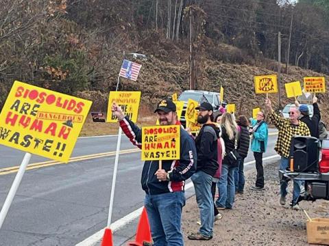 Citizens protesting the spread of biosolids and their smell are shown near the entrance to Copperhill Industries Saturday morning. They were forced to move twice, despite permission from race officials to hold their event.