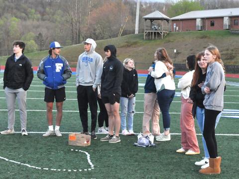 Special Education teacher Katie Wynn (center of photo with back to camera) comforts a students as she embraces her with a hug as students, teachers and members of the community gathered last week on the football field at Fannin County High School to remember John Holsonback and honor his family. 