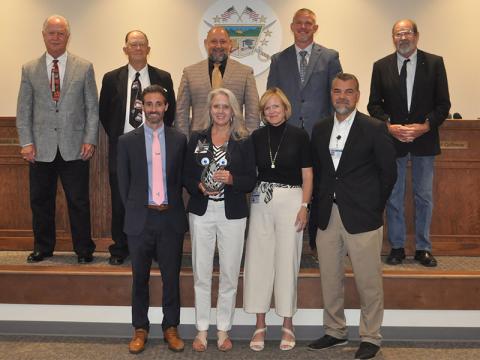 The Fannin County School System honored Martha Williams for her hours of hard work and dedication to the Community Eligibility Provision program. She is shown with front row, from left, Chief Academic Officer Dr. Lucas Roof, Williams, School Superintendent Shannon Dillard, and  Chief Operation Officer and Senior Executive Darren Danner; and back ro, board members, Terry Bramlett, Bobby Bearden, Mike Cole, Chad Galloway, Lewis DeWeese. 