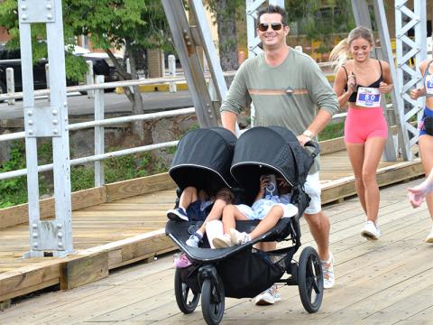 The event is not just for runners, but invites everyone to enjoy the event as this father shows as he pushes two youngsters across the iconic steel bridge.