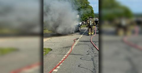 This car fire had traffic backed up when a vehicle pulled in front of a responding fire fighter.