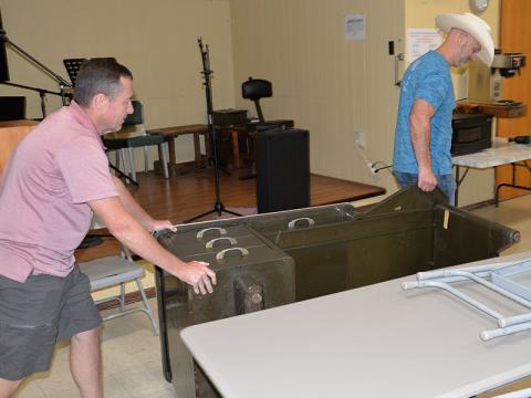 Keith Barker, left, Polk County District 3 commissioner, and Polk County District 2 Commissioner Shane Bowman remove a heavy metal desk from the Copper Basin Community Center. The desk was a piece of surplus property that was cluttering the building.