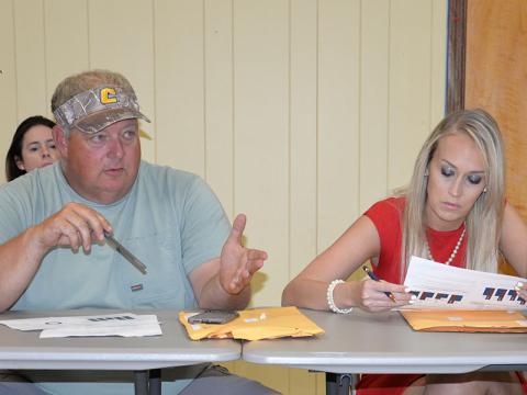 Polk County Commissioner Greg Brooks makes a point about total tourism dollars versus tax dollars as Commissioner Samantha Trantham studies a Department of Tourism handout.