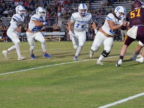 Jacob Dye (#60) and Cooper Born (#14) clear a patch for Carson Callihan (#25) after he takes a handoff from Lawson Sullivan (#2) in the Fannin County Rebels road game against the Dade County Wolverines in Trenton, Georgia, Friday night. The Rebels won the contest to go 5-0 on the season.