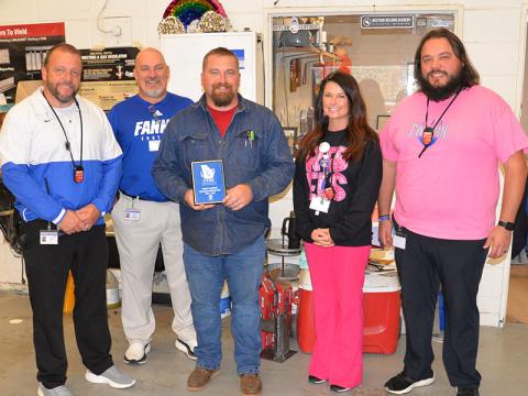 Terry Flowers, center, a welding teacher at Fannin County High School, was surprised Friday with a plaque recognizing him as one of the top 20 Career, Technical and Agricultural Education teachers in Georgia. Among those on hand to present the plaque were, from left, Dr. Scott Ramsey, David Henson, Amanda Housley, and Jeremy King.